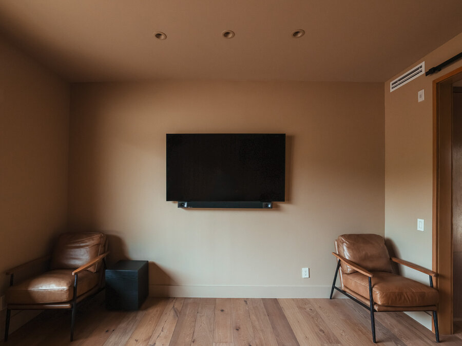 A media room with a TV mounted on the wall.