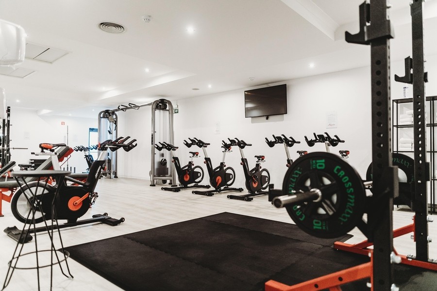 Small gym featuring weight machines and stationary bikes.