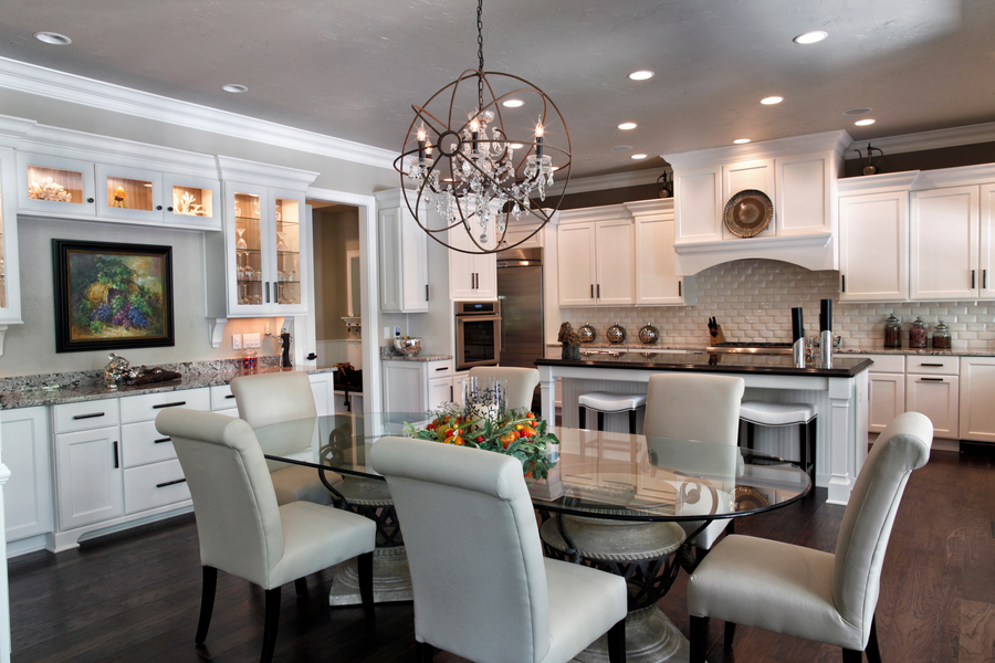An open-concept kitchen and dining room with elaborate lighting design and statement lighting fixtures controlled by Control4.