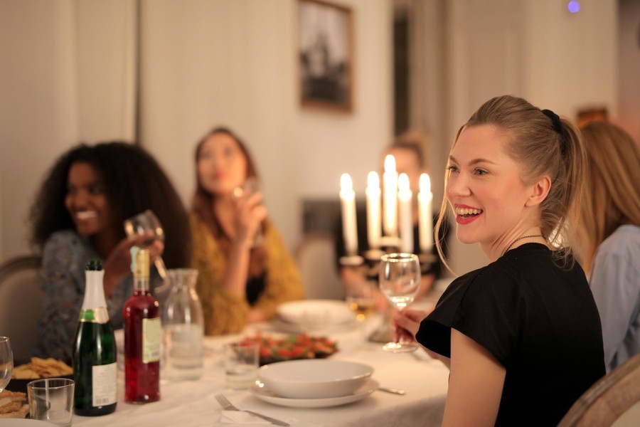 A group of people is seated around a holiday table enjoying a meal.