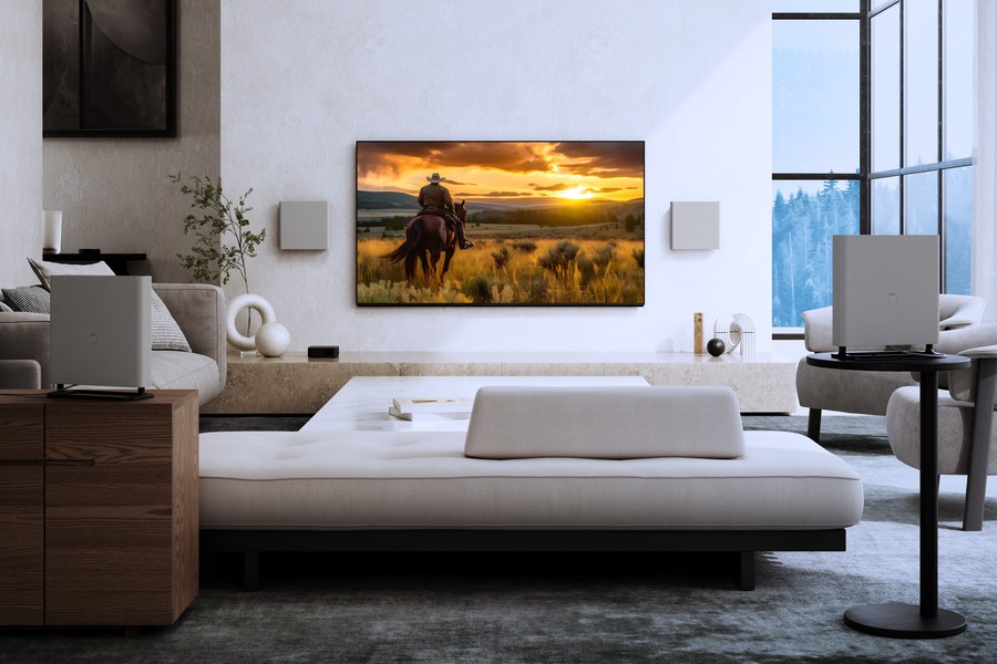 Media room with surround sound speakers and a large Sony TV displaying a western scene at sunset in a luxury living space.