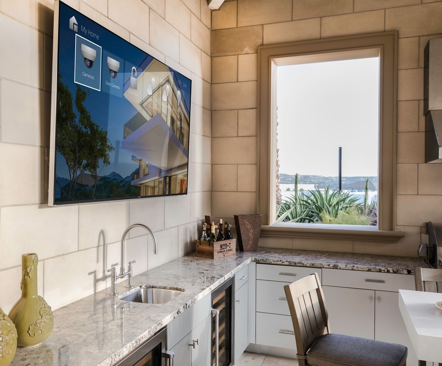 kitchen counter overlooking an open window with a TV display mounted above it.